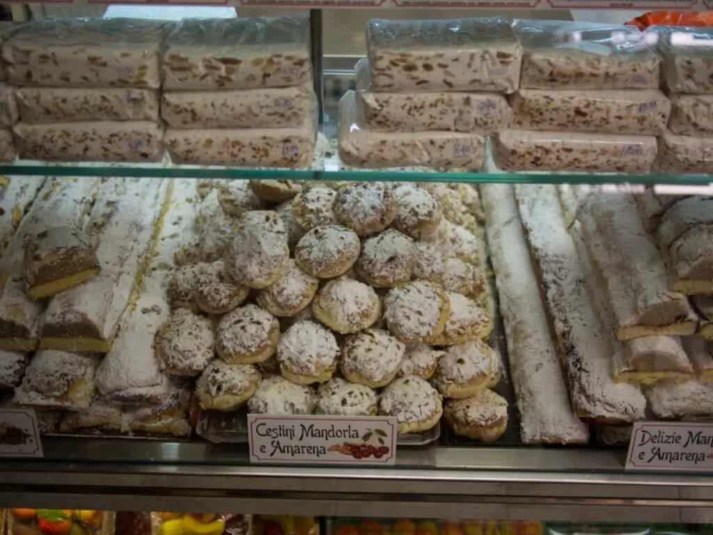 pair Cassatelle and almond pastries behind the counter glass