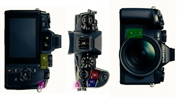 An Olympus E-M1 camera body and lenses laid out on a white surface.