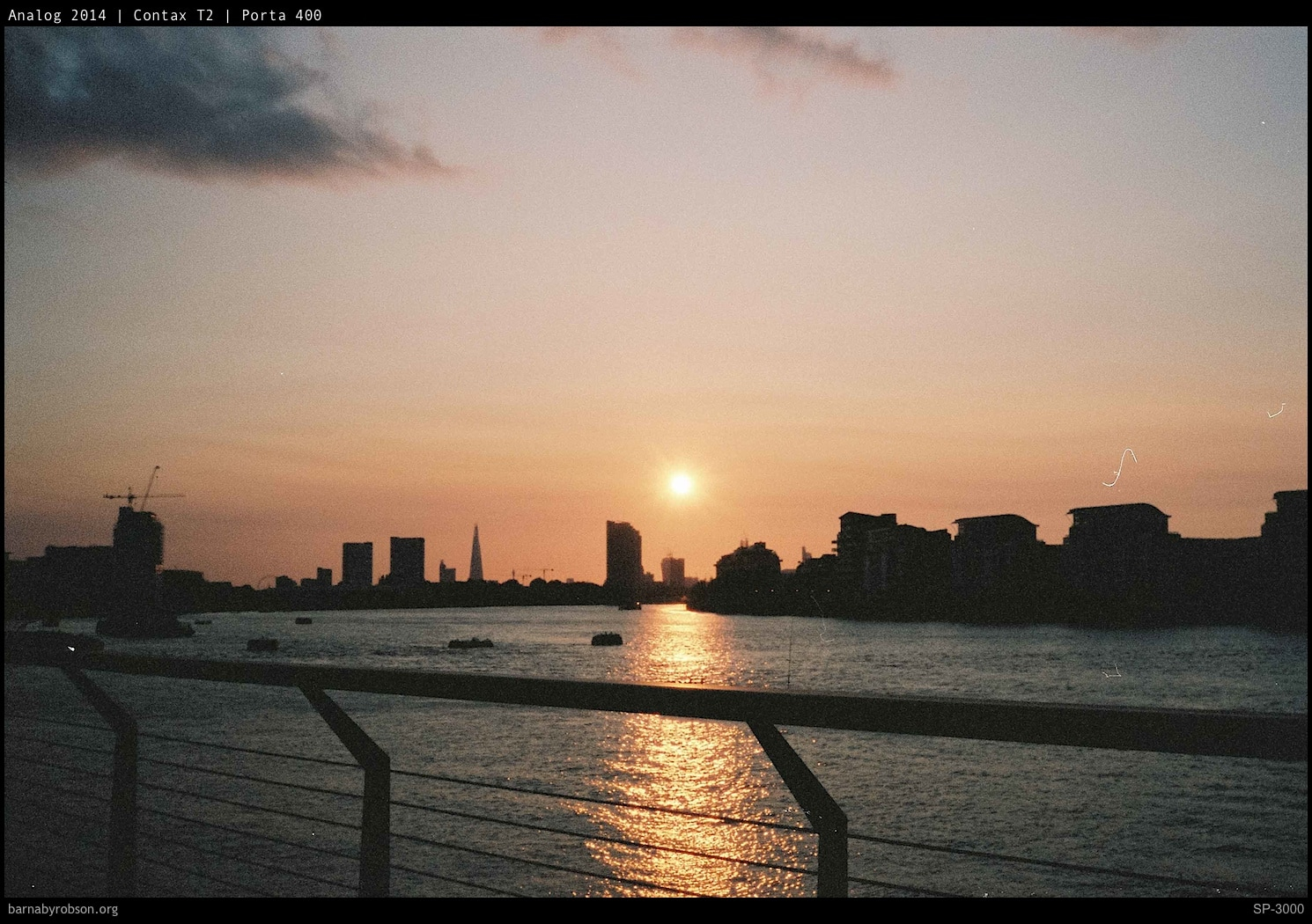 A river sunset over a city skyline, shot on film